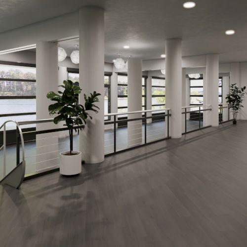The image shows a modern, open indoor space with large windows, potted plants, pillars, and a sleek handrail.